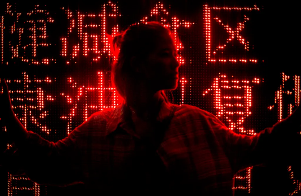 Silhouette of a woman in front of a red LED sign in Chinese characters